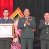 Thượng tướng Phùng Sĩ Tấn, Phó Tổng Tham mưu trưởng Quân đội Nhân dân Việt Nam trao Huân chương Bảo vệ Tổ quốc hạng Ba cho Trung tâm hành động bom mìn Quốc gia Việt Nam. (Ảnh: Trọng Đức/TTXVN)