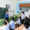 Một giờ học của học sinh khuyết tật khiếm thính khối 2-3, cô giáo hướng dẫn học sinh diễn đạt từ ngữ bằng ngôn ngữ ký hiệu. (Ảnh: Phan Sáu/TTXVN)