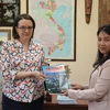 Phóng viên thường trú TTXVN trao tặng ấn phẩm Báo Ảnh Việt Nam cho Giám đốc Trung tâm ASEAN tại Đại học quan hệ quốc tế MGIMO thuộc Bộ Ngoại giao Nga Ekaterina Koldunova. (Ảnh: Quang Vinh/TTXVN)