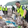 Nhân viên Ban Quản lý vịnh Nha Trang cùng các tình nguyện viên dọn rác tại khu vực bờ kè biển Vĩnh Trường, sát bến tàu du lịch Nha Trang. (Ảnh: Phan Sáu/TTXVN)