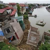 Hiện trường vụ sạt lở tại tuyến đê hữu sông Cầu đoạn qua khu Vạn Phúc, phường Vạn An (thành phố Bắc Ninh, tỉnh Bắc Ninh) khiến nhiều ngôi nhà bị rạn nứt, trôi xuống sông. (Ảnh: Thanh Thương/TTXVN)