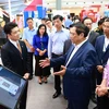 Thủ tướng Phạm Minh Chính tham quan trưng bày về ứng dụng chuyển đổi số trong lĩnh vực ngân hàng. (Ảnh: Dương Giang/TTXVN)