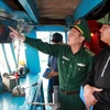 Kiểm tra thiết bị định vị tàu cá. (Ảnh: Nguyễn Lành/ TTXVN)