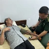 Cán bộ Quân y Đồn Biên phòng Cửa khẩu Cảng Gianh thăm khám sức khỏe ban đầu cho thuyền viên bị nạn Nguyễn Văn Bình. (Ảnh: TTXVN phát)