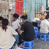 Học sinh, sinh viên hồn nhiên ngồi ăn quán xiên nướng vỉa hè quanh khu vực trường Tiểu học Lê Ngọc Hân, quận Hai Bà Trưng. (Ảnh: Phương Anh/TTXVN)