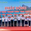 Các đại biểu tặng quà cho các cháu học sinh có hoàn cảnh khó khăn vượt khó, học giỏi. (Ảnh: Huỳnh Sơn/TTXVN)