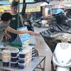 Người dân mua rượu nếp tại chợ Hàng Bè sáng Tết Đoan Ngọ. (Ảnh: Hoàng Hiếu/ TTXVN)