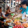 Phát tờ rơi, tuyên truyền chính sách bảo hiểm xã hội cho người dân thành phố Nam Định. (Ảnh: Nguyễn Lành/TTXVN)
