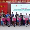 Đoàn công tác trao xe đạp và quà tặng trẻ em có hoàn cảnh khó khăn xã Chiêu Lưu. (Ảnh: Lâm Khánh/Vietnam+)