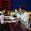 Người dân phường Long Tâm ký nhận hồ sơ nhận chi trả, hỗ trợ bồi thường giải phóng mặt bằng dự án đường nối cao tốc. (Ảnh: Hoàng Nhị/ TTXVN)