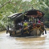 Du lịch bằng thuyền dưới tán dừa được du khách trong và ngoài nước lựa chọn khá nhiều khi đến Bến Tre. (Ảnh: Chương Đài/TTXVN)