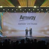 Ông Huỳnh Thiên Triều, Tổng Giám đốc Amway Việt Nam (bên trái) vinh dự được trao tặng phiên bản vàng của Cúp Harmonia với thành tích 5 năm đạt giải thưởng HR Asia - Nơi làm việc tốt nhất châu Á 2024. (Nguồn: Vietnam+)