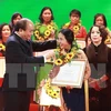 Thủ tướng Nguyễn Xuân Phúc tặng hoa cho các phụ nữ điển hình tiên tiến. (Ảnh: TTXVN)