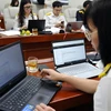 Các công chức ngành thuế đang hỗ trợ trực tuyến quyết toán thuế năm 2022. (Ảnh: CTV/Vietnam+)