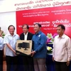 Thứ trưởng Trương Minh Tuấn tặng máy tính cho Bộ Thông tin Văn hóa và Du lịch Lào. (Ảnh: CTV/Vietnam+)