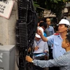 Trưởng đoàn thanh tra Nguyễn Văn Minh (đội mũ) kiểm tra sai sót của doanh nghiệp trong quá trình lắp đặt đường dây, cáp đi nổi. (Ảnh: T.H/Vietnam+)