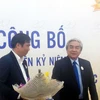 Bộ trưởng Nguyễn Quân (phải) tặng hoa chúc mừng diễn đàn. (Ảnh: T.H/Vietnam+)