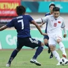Tiền vệ Quang Hải (áo số 19) trong một pha tranh bóng với cầu thủ đội tuyển Olympic Nhật Bản. (Ảnh: Hoàng Linh/TTXVN) 