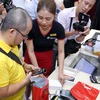 Nhiều người đến FPT Shop từ rất sớm để sở hữu iPhone mới chính hãng. (Ảnh: CTV/Vietnam+)