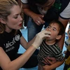 Tara Moss cho trẻ em Syria uống vắcxin chống bại liệt. (Nguồn: UNICEF)