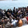 Tàu của lực lượng bảo vệ bờ biển Libya đưa những người di cư trái phép tới cảng Garabulli, Libya ngày 6/6, sau khi họ được cứu. (Nguồn: THX/TTXVN)