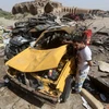 Xe ôtô bị phá hủy sau vụ đánh bom của IS tại thị trấn Khan Bani Saad. (Nguồn: AFP/TTXVN)
