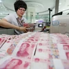Kiểm tiền nhân dân tệ tại ngân hàng ở Liên Vận Cảng, tỉnh Giang Tô, Trung Quốc ngày 11/8. (Nguồn: THX/TTXVN)