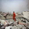 Nhân viên Chữ thập đỏ Syria tìm kiếm người mất tích trong đống đổ nát sau vụ không kích ở Douma ngày 22/8. (Nguồn: AFP/TTXVN)