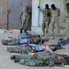 Binh sỹ Somalia điều tra bên thi thể các tay súng Shebab sau vụ giao tranh ở thủ đô Mogadishu. (Nguồn: AFP/TTXVN)