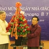 Thay mặt các cựu lưu học sinh Việt Nam từng học tại Trường Đại học Quốc gia Lào, Đại sứ Nguyễn Mạnh Hùng tặng hoa ông Phankham Viphavan, Ủy viên Bộ Chính trị, Phó Thủ tướng Chính phủ, Bộ trưởng Giáo dục và Thể thao Lào. (Ảnh: Phạm Kiên/TTXVN)