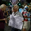 Hai người đàn ông, một tay cầm biểu ngữ "mất giá = điên rồ," trong một cuộc biểu tình chống lại các biện pháp kinh tế chủ tịch Mauricio Macri. (Nguồn: AP)