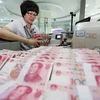 Kiểm tiền nhân dân tệ tại ngân hàng ở Liên Vận Cảng, tỉnh Giang Tô, Trung Quốc. (Nguồn: THX/TTXVN) 