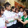 Bà Nguyễn Minh Tâm - Giám đốc Chi nhánh Vinamilk tại Hà Nội trao quà cho các em học sinh.