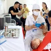 Nhân viên y tế tư vấn tiêm chủng cho trẻ tại tỉnh Bắc Giang. (Ảnh: TTXVN)