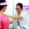Nhân viên y tế khám sàng lọc ung thư vú cho người dân. (Ảnh: TTXVN)