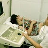 Nhân viên y tế kiểm tra sức khỏe sinh sản cho một phụ nữ. (Ảnh: TTXVN)