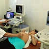 Nhân viên y tế kiểm tra sức khỏe cho một thai phụ. (Ảnh: TTXVN/Vietnam+)