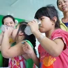 Trẻ em uống sữa dinh dưỡng tại buổi lễ triển khai chương trình. (Ảnh: PV/Vietnam+)
