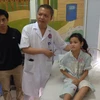 Giáo sư Lê Ngọc Thành thăm hỏi, kiểm tra sức khỏe bệnh nhân Tân sau mổ. (Ảnh: T.G/Vietnam+)