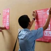 Học sinh tham gia dán tờ rơi tuyên truyền phòng chống bệnh do virus Zika. (Ảnh: TTXVN/Vietnam+)