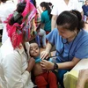 Nhân viên y tế khám cho trẻ bị dị tật môi tại Bệnh viện Hữu nghị Việt Nam-Cuba. (Ảnh: PV/Vietnam+)