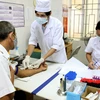 Nhân viên y tế xét nghiệm tự nguyện điều trị cho người nhiễm HIV. (Ảnh: TTXVN/Vietnam+)