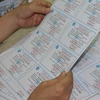 kiểm tra thẻ bảo hiểm y tế trước khi phát hành. (Ảnh: PV/Vietnam+)
