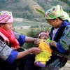 Cô đỡ thôn bản huyện Mù Cang Chải (bên trái) hướng dẫn bà mẹ chăm sóc trẻ sơ sinh. (Ảnh: TTXVN/Vietnam+)