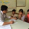 Bác sỹ làm các thủ tục khám bệnh cho trẻ em tại Lai Châu. (Ảnh: PV/Vietnam+)