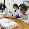 Nhân viên y tế khám,theo dõi sức khỏe cho người dân. (Ảnh: TTXVN/Vietnam+)