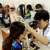 Bác sỹ khám và điều trị cho người đau mắt đỏ tại Bệnh viện Mắt Trung ương. (Ảnh: TTXVN/Vietnam+)