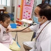 Bác sỹ khám bệnh cho trẻ em. (Ảnh: TTXVN/Vietnam+)