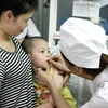 Nhân viên y tế cho trẻ uống Vitamin A. (Ảnh: Dương Ngọc/TTXVN)