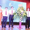 Ông Trương Minh Tuấn, Ủy viên Trung ương Đảng, Bộ trưởng Bộ Thông tin và Truyền thông tặng hoa chúc mừng Khoa Báo chí. (Ảnh: Anh Linh/TTXVN phát)